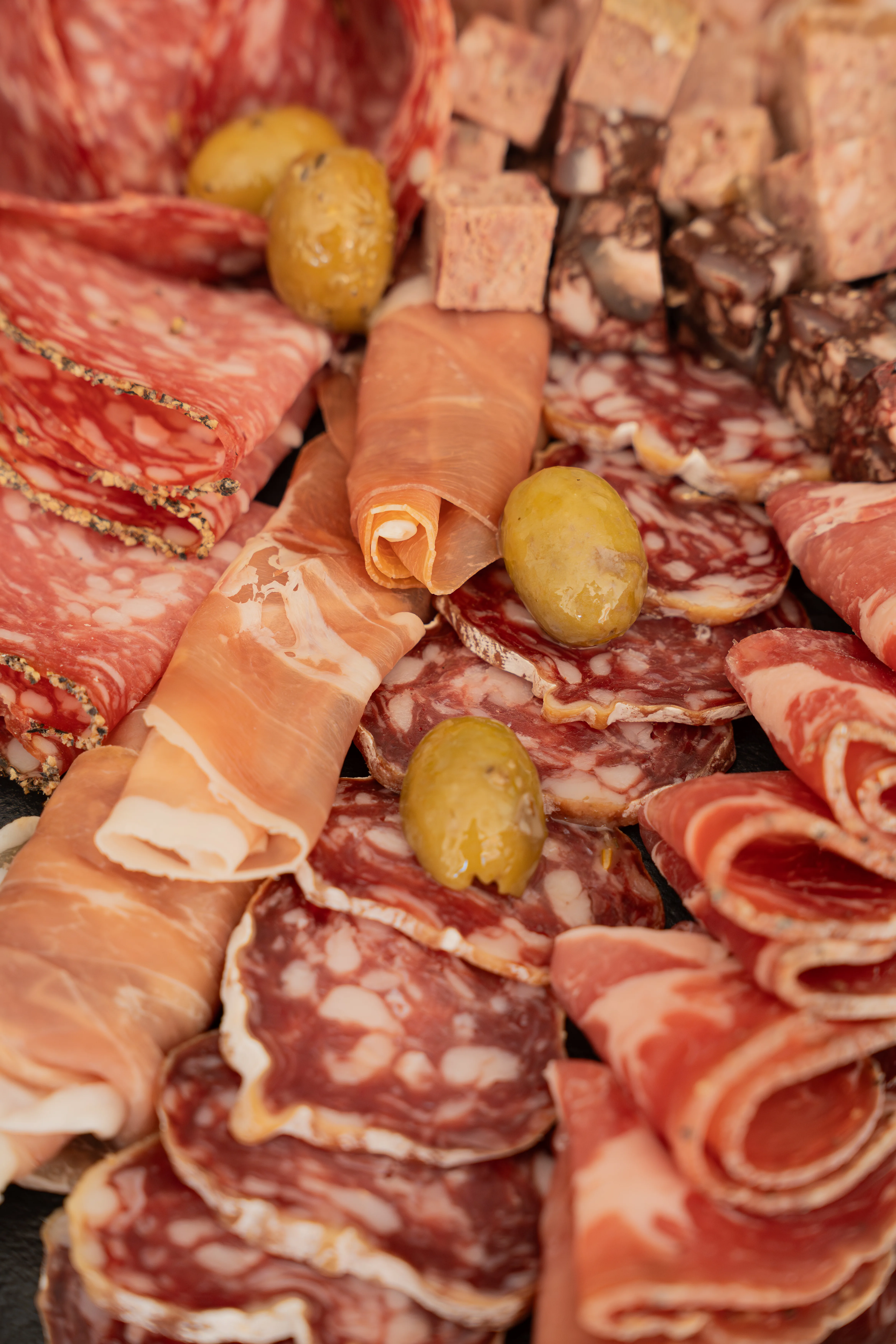 Charcuteries fines (salami, jambon, saucissons) et olives en gros plan