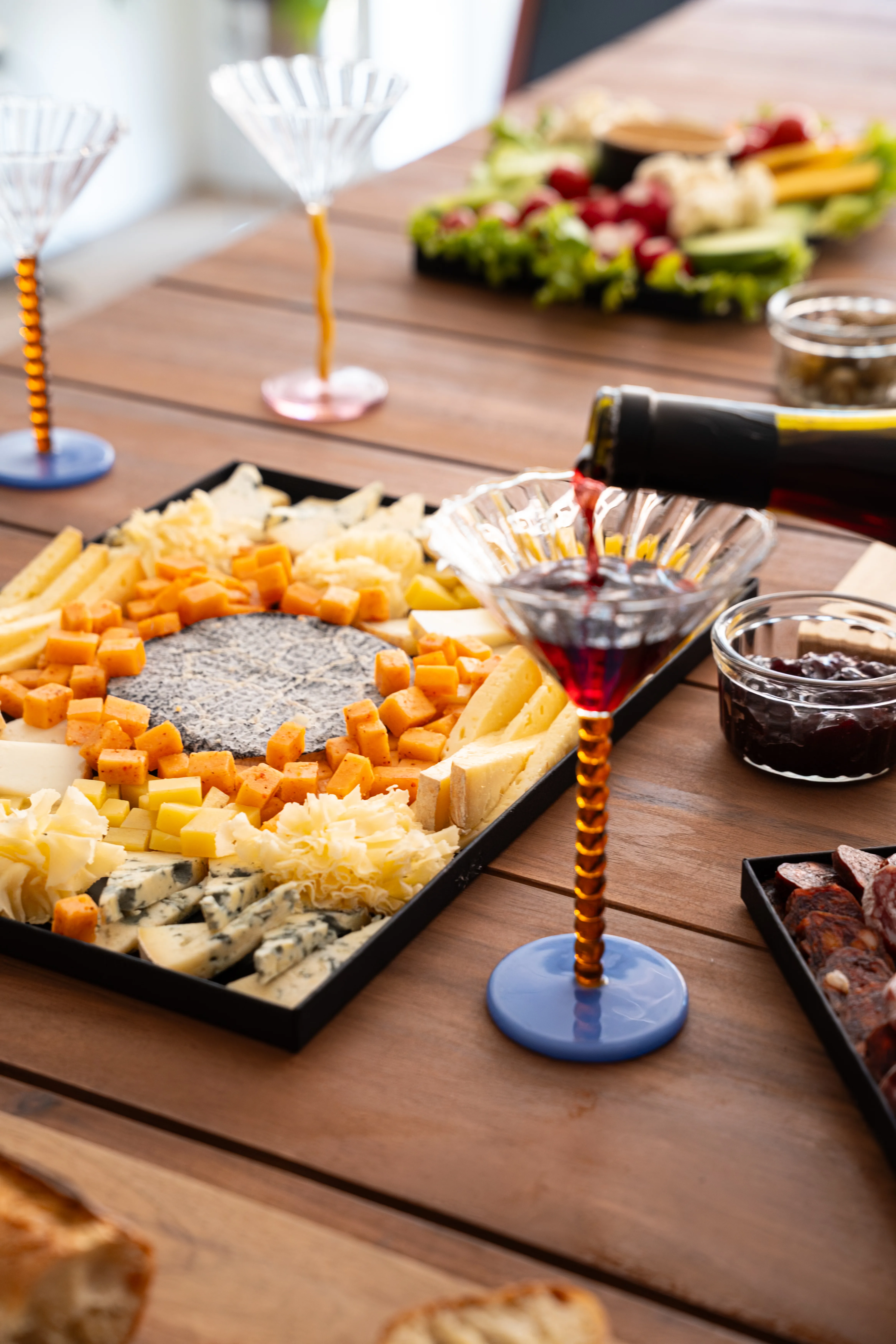 Planche de fromages variés présentée avec coupes de vin